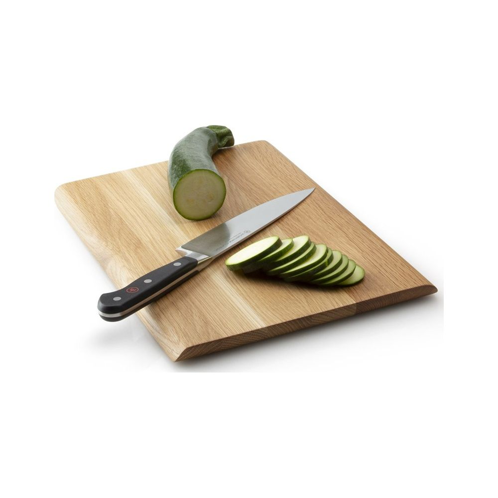 Ein Messer liegt auf einem Holzbrett neben einer Zucchini und ihren Scheiben.