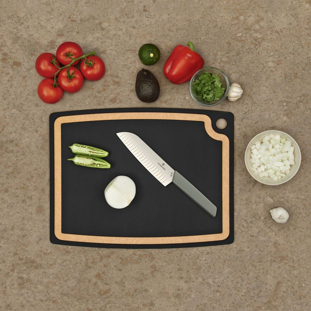 Bir bıçak, soğan, jalapeño biberi, domates, avokado, misket limonu, dolmalık biber ve kişnişin yanında kesme tahtasında duruyor.