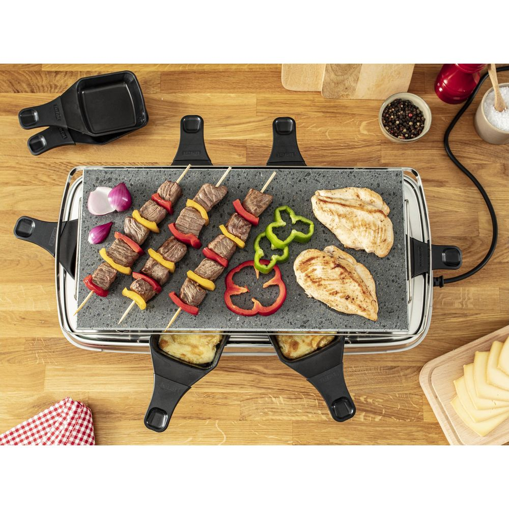 Raclettegrill mit Fleischspießen, Hähnchenbrust, Paprika und Käsepfannen.