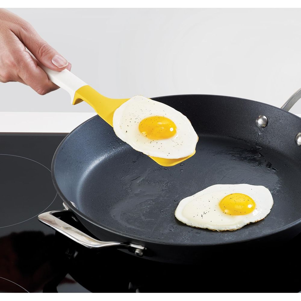 Sarı bir spatula ile tavadan bir sahanda yumurta kaldırılıyor.