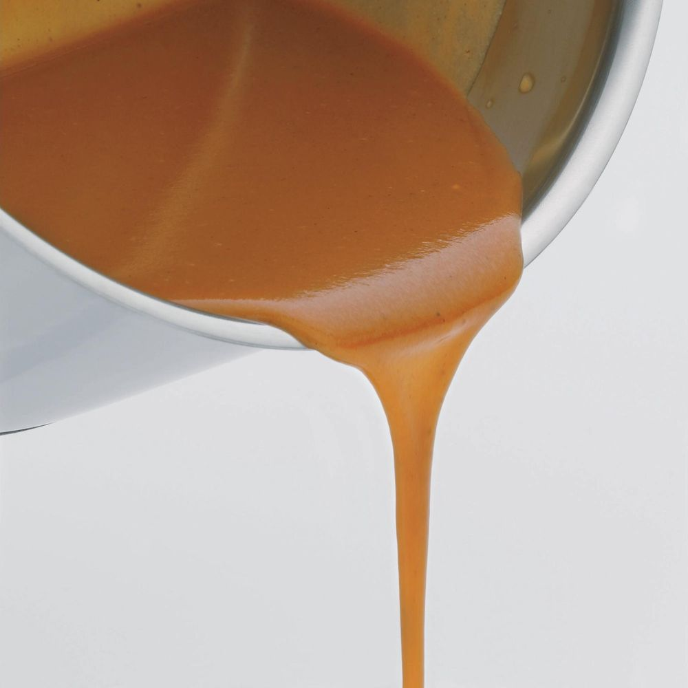 Brązowy płyn wylewa się z metalowego pojemnika.