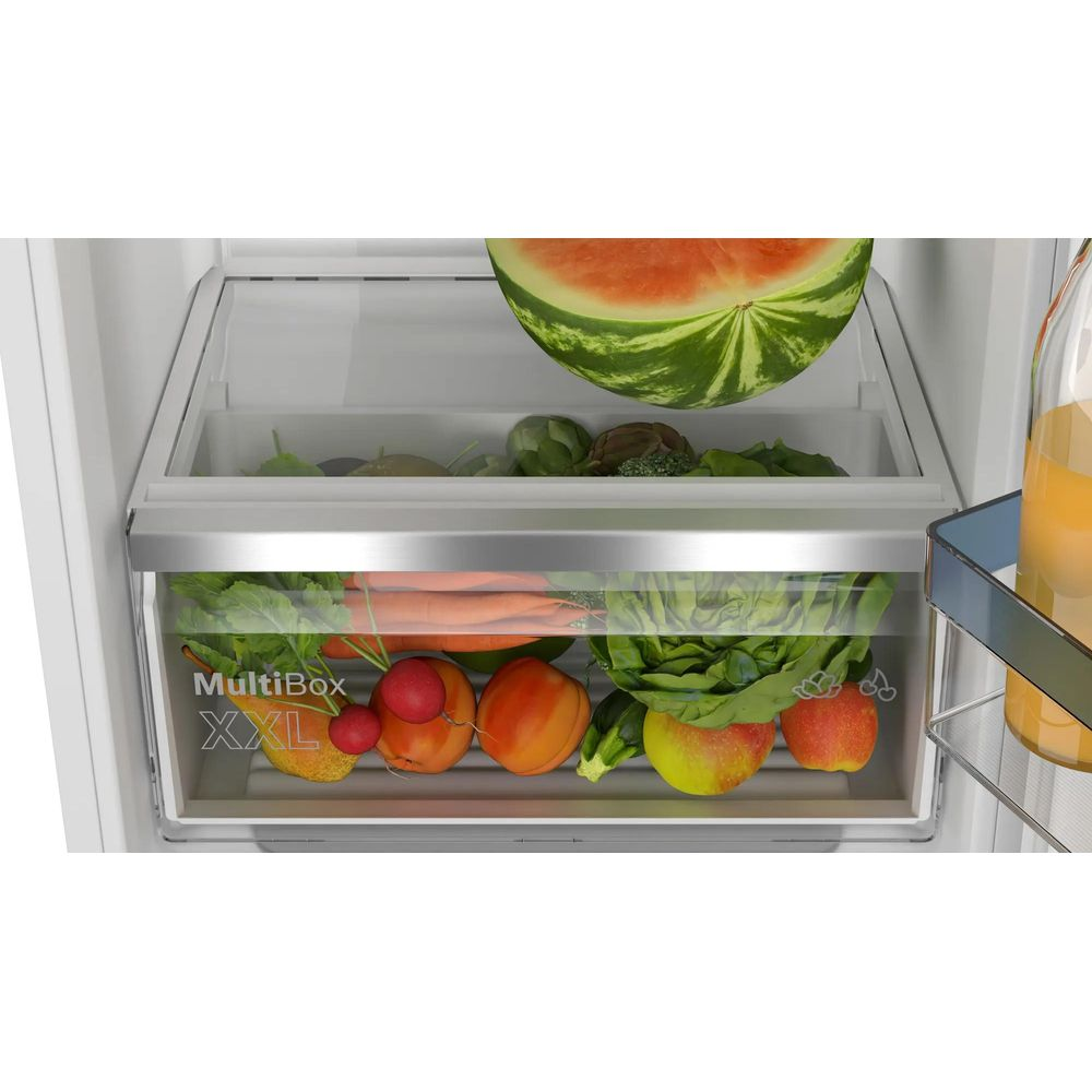 Wassermelone, Gemüse und Obst in Kühlschubladen. Saftflasche daneben.