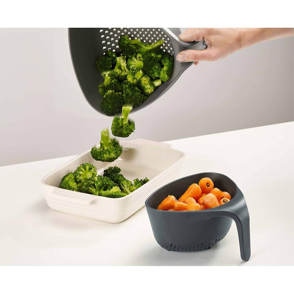El brócoli se vierte de un colador a una fuente para hornear. Zanahorias en un bol.