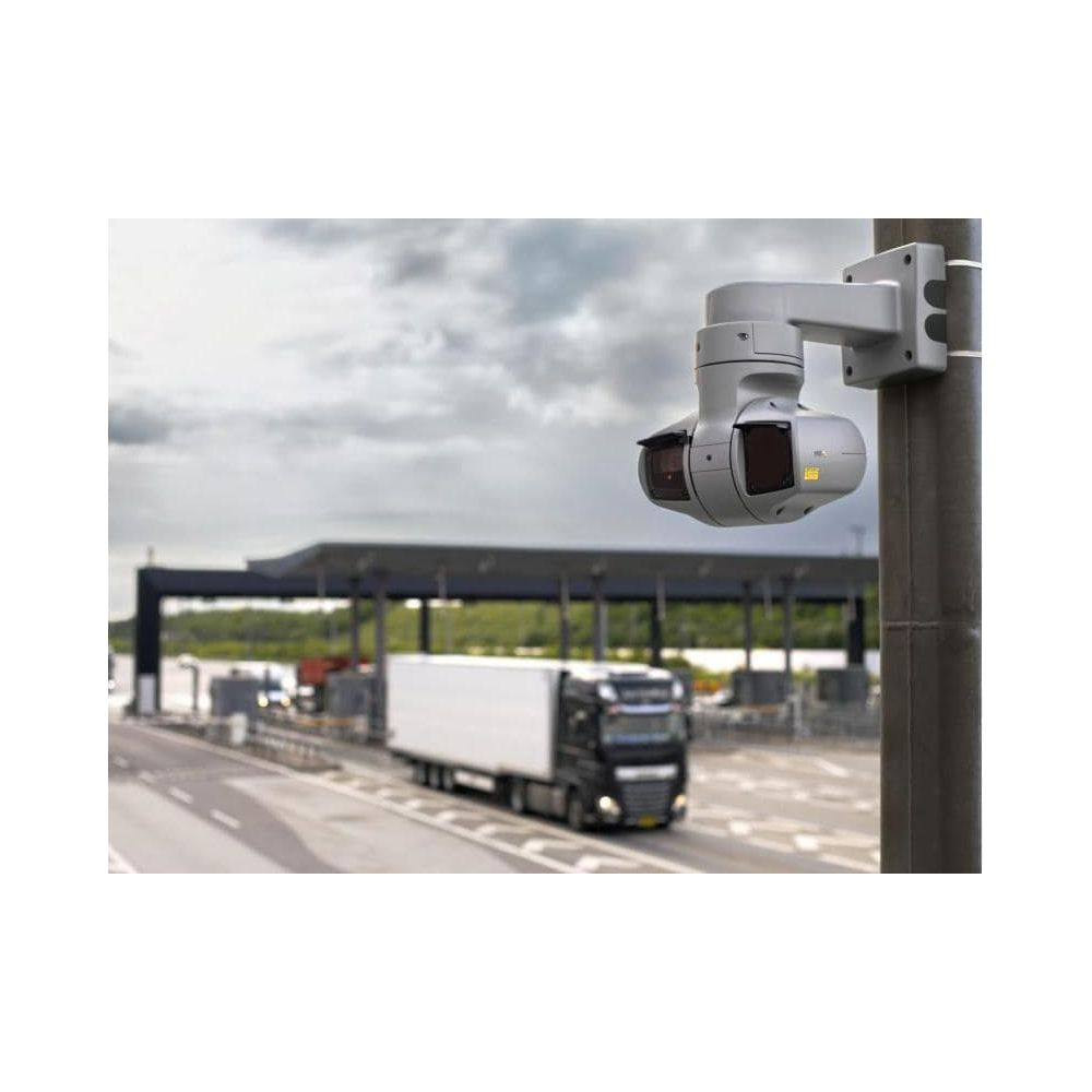 Kamera na słupie przed punktem poboru opłat z ciężarówką na drodze.