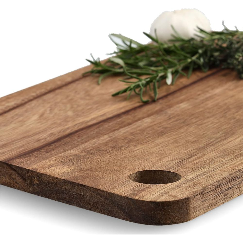Holzschneidebrett mit Rosmarin und Knoblauch, Nahaufnahme.