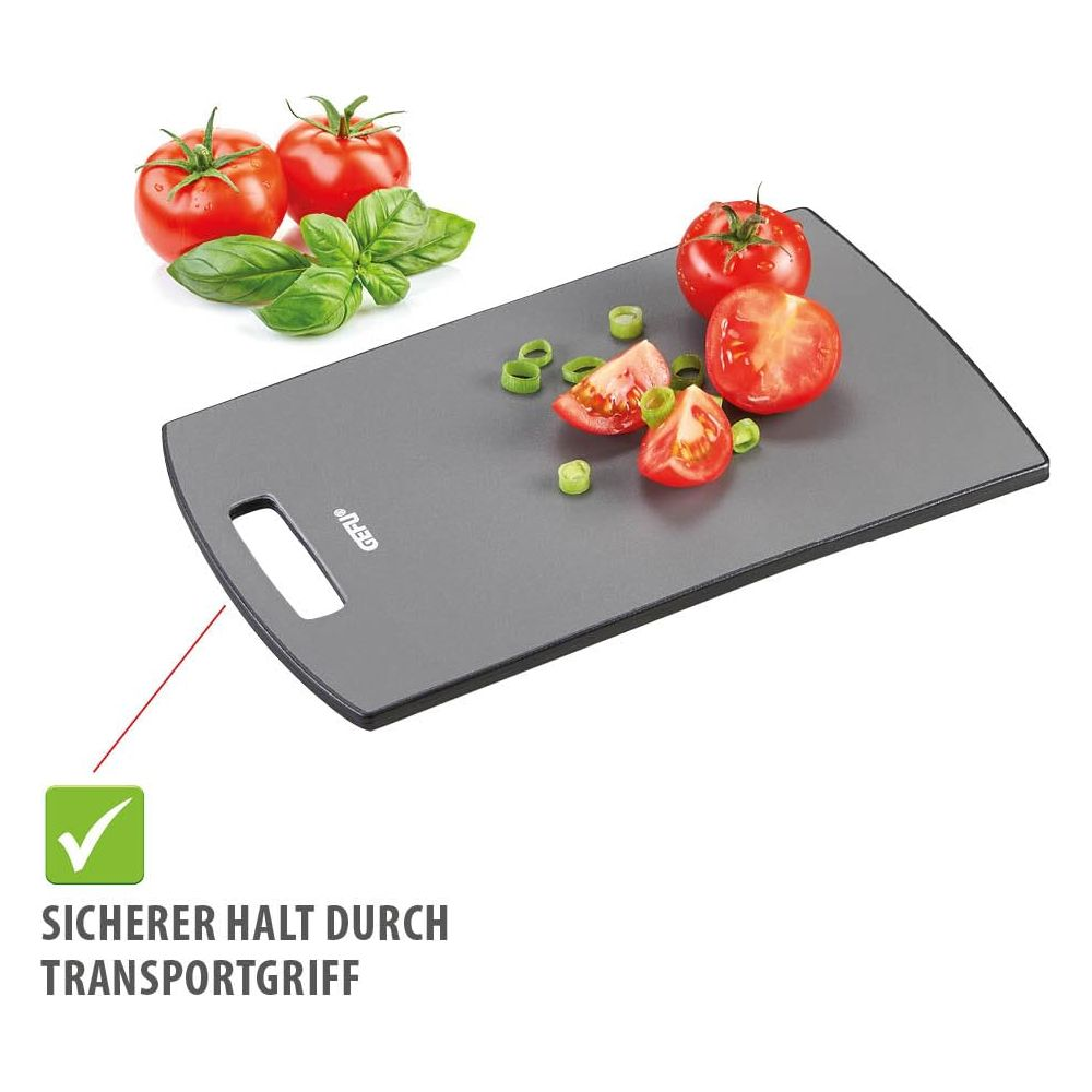 Graues Schneidebrett mit Tomaten und Basilikum.