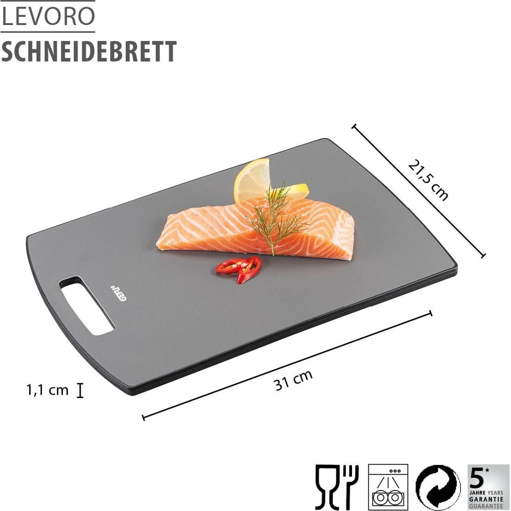 Graues Schneidebrett mit Lachs, Zitrone, Chili und Kräutern.
