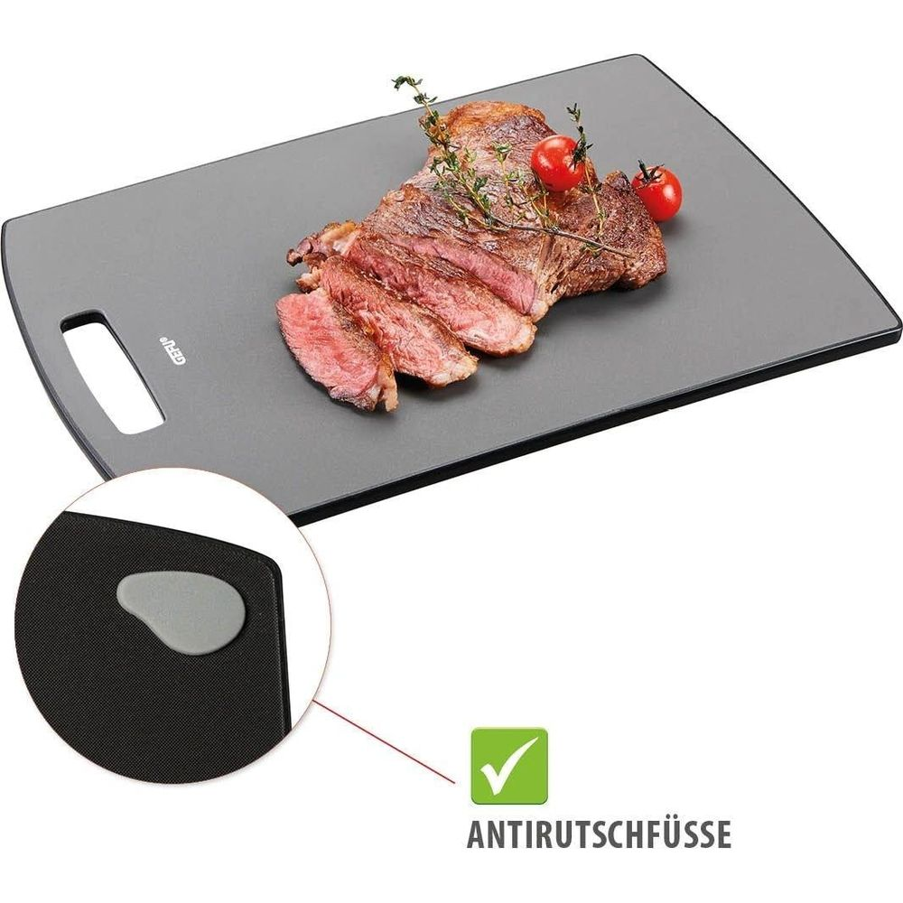 Ein gebratenes Steak mit Kirschtomaten und Rosmarin auf einem schwarzen Schneidebrett.