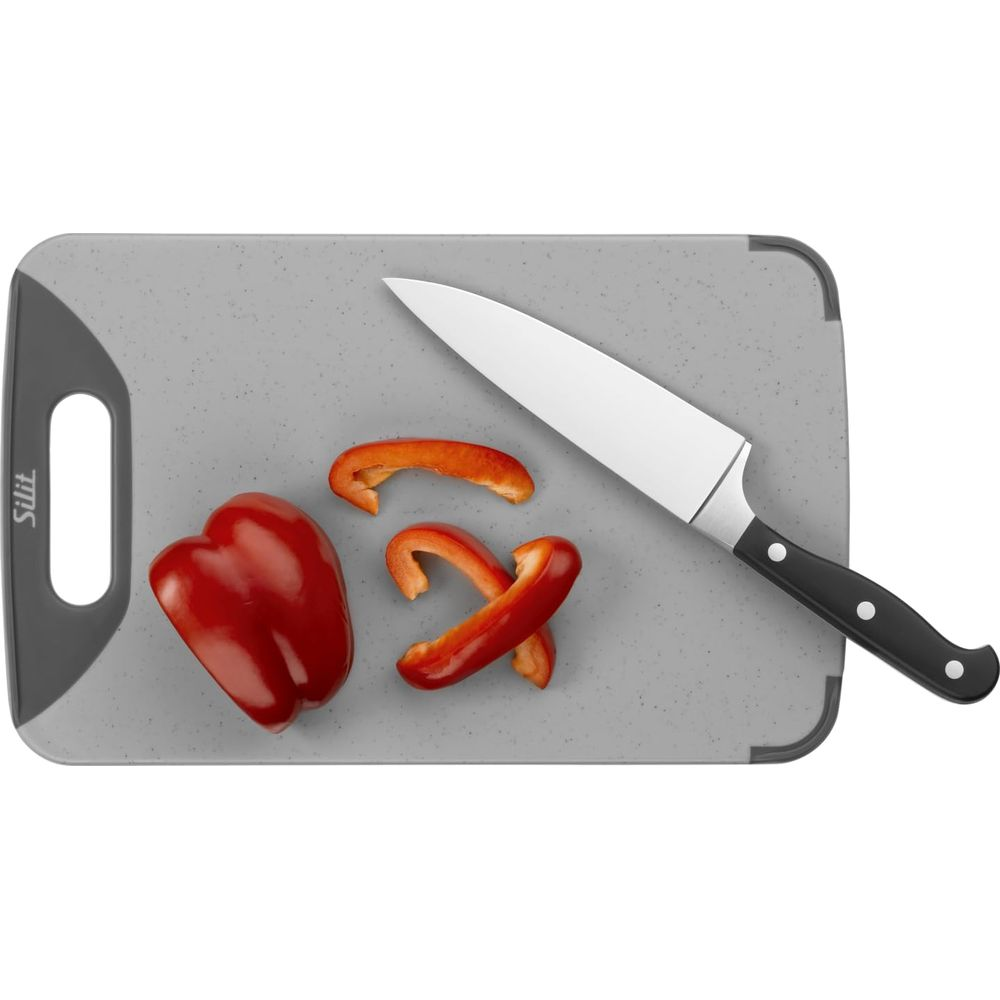 Ein Messer liegt neben einem roten Paprika auf einem grauen Schneidebrett.