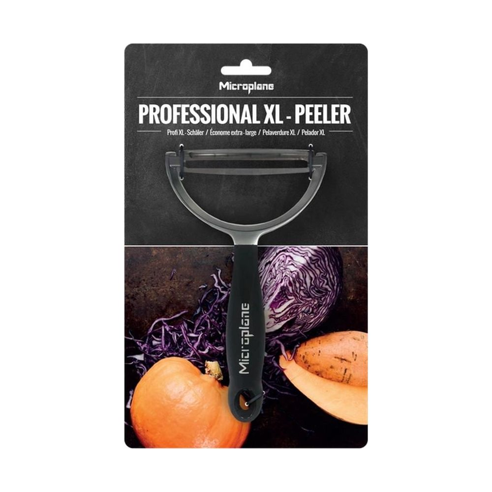 Microplane XL Schäler mit schwarzem Griff, daneben rote Zwiebeln und Karotten.