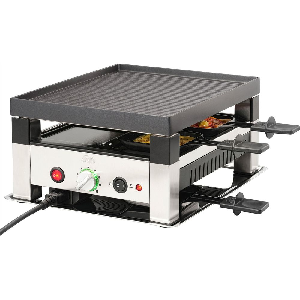 Kompakter Raclette-Grill mit Grillplatte und vier Pfännchen, silberfarben.