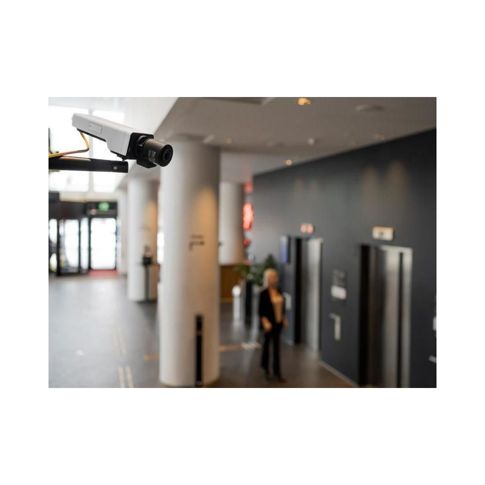 Kamera monitoringu w holu hotelowym z windami i kobietą.