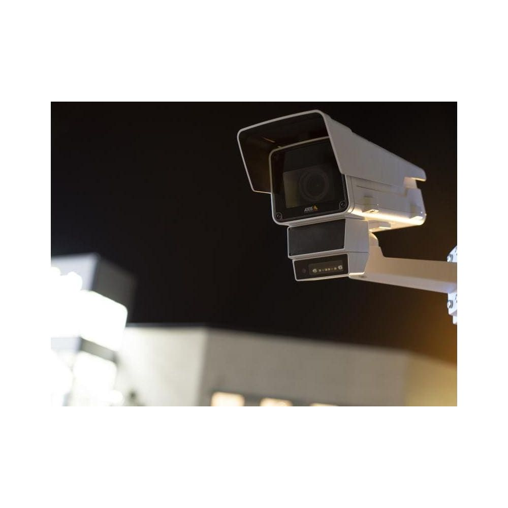 Biała kamera monitorująca z dwoma obiektywami jest zamontowana na słupie.