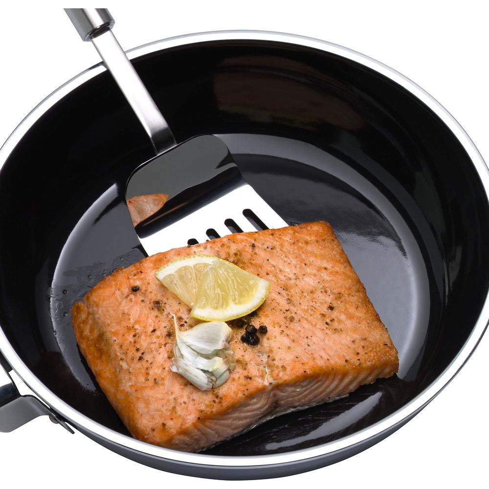 Tavada limonlu ve sarımsaklı somon filetosu, spatula ile çevriliyor.