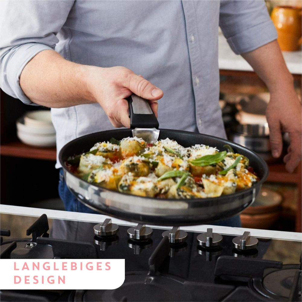 Une personne tient une poêle remplie de nourriture sur une cuisinière à gaz.