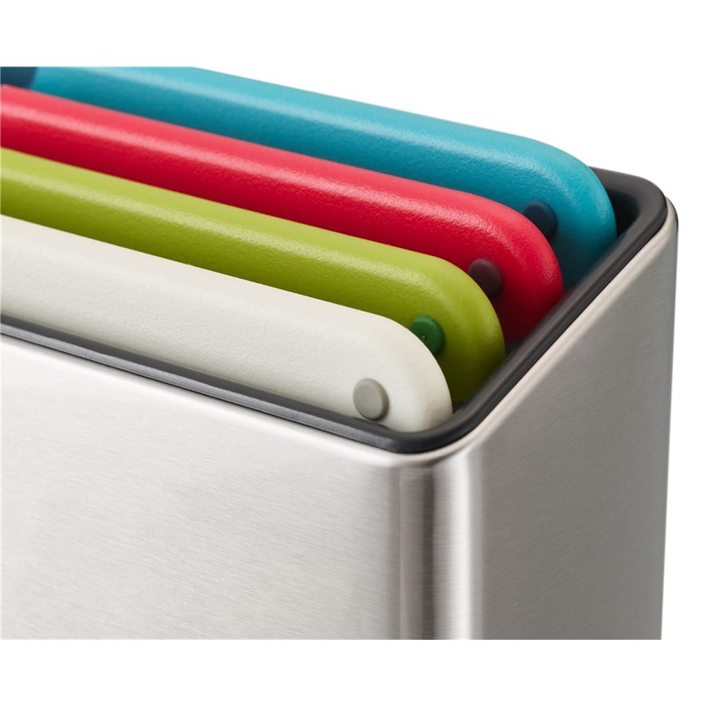 Vier bunte Schneidebretter (weiß, grün, rot, blau) in einem Metallständer.
