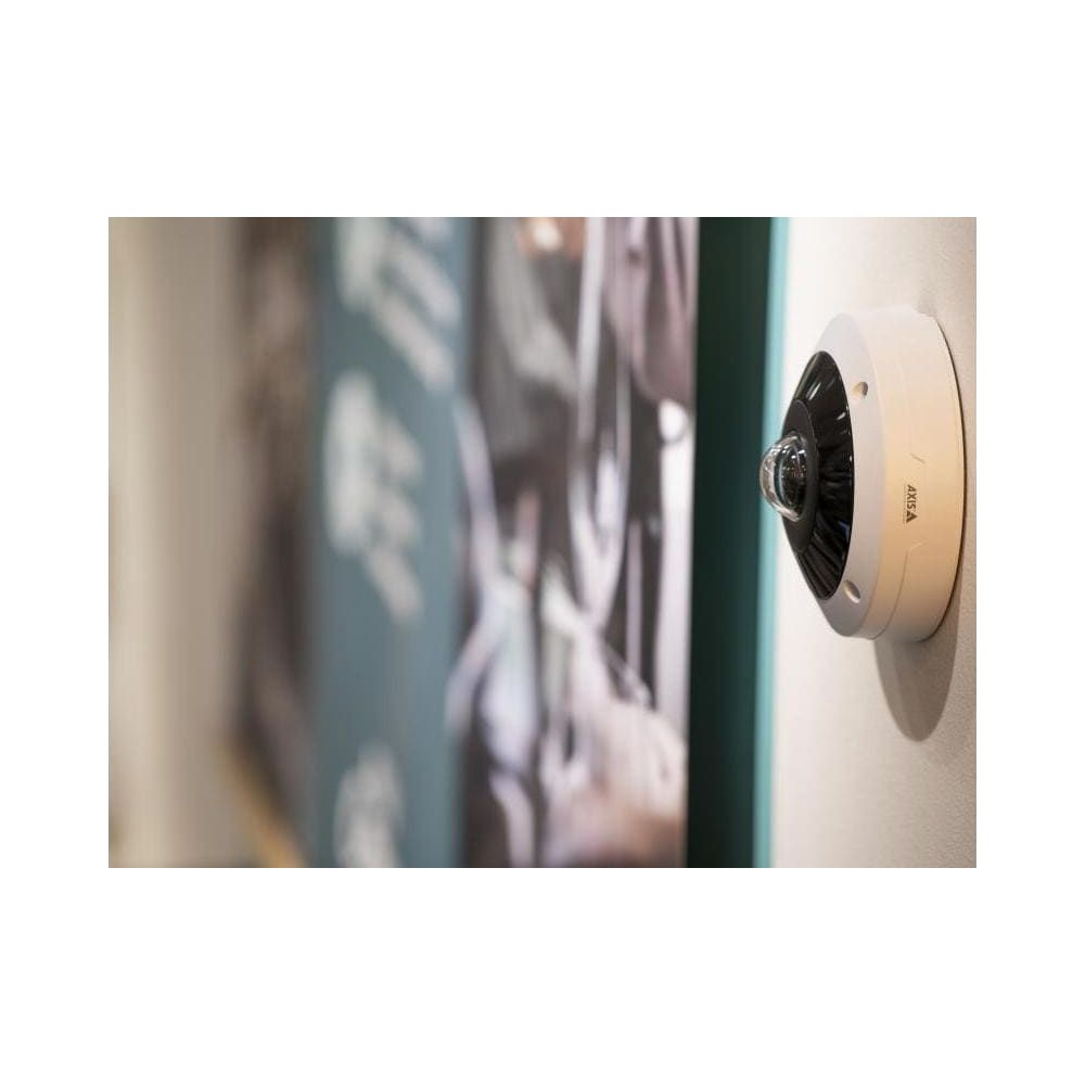 Biała kamera kopułkowa jest zamontowana na ścianie.