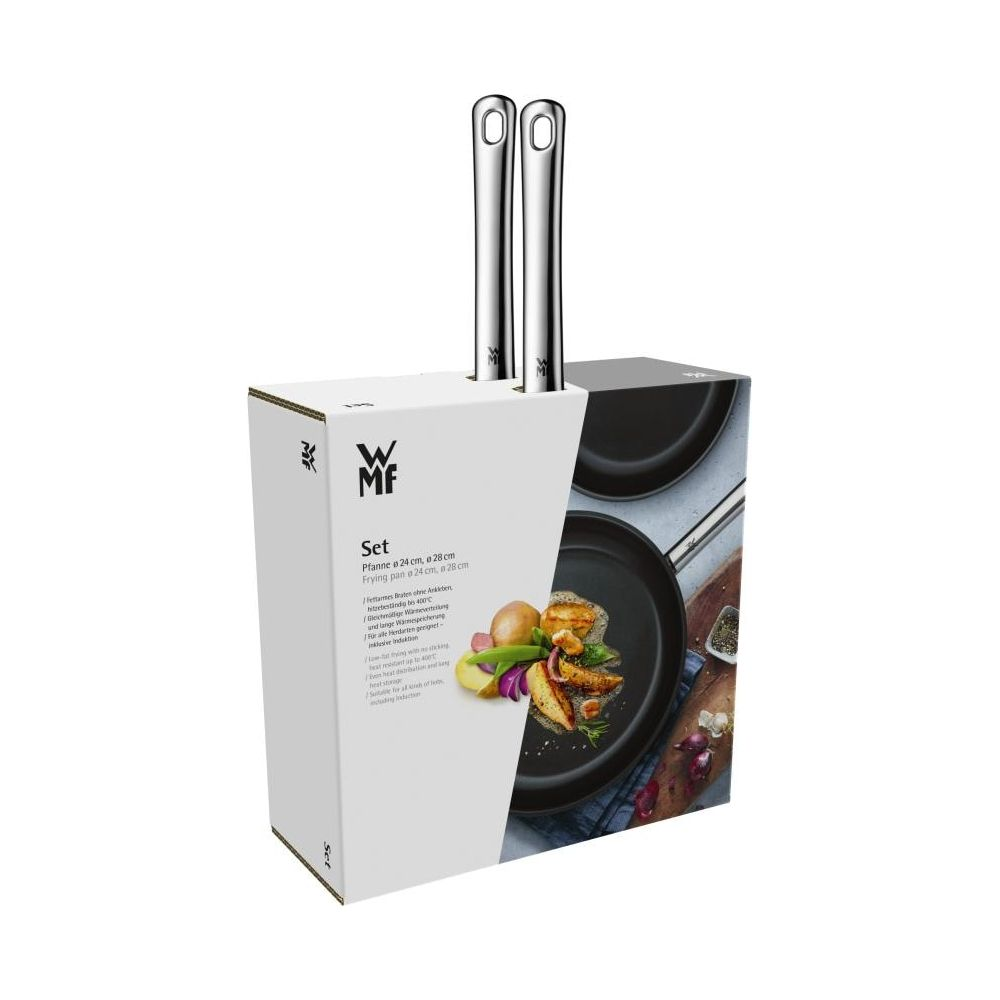 Set mit zwei Bratpfannen, Löffel und Gemüse auf Verpackung