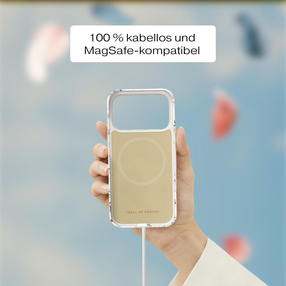 Eine Hand hält eine goldene Handyhülle mit Blumenmuster, MagSafe-kompatibel.