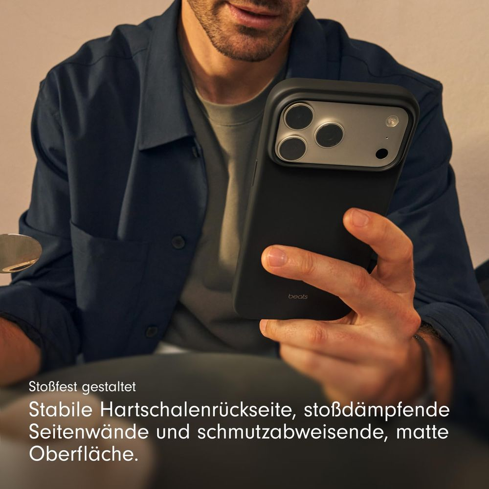 Un hombre sostiene un teléfono negro con tres lentes de cámara y el logo de Beats.