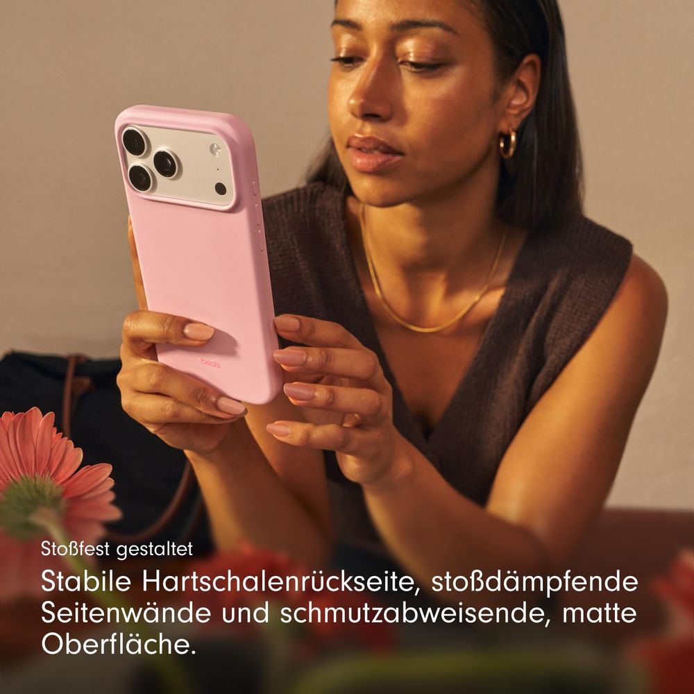 Kobieta trzyma różowy telefon z aparatem i logo Beats.