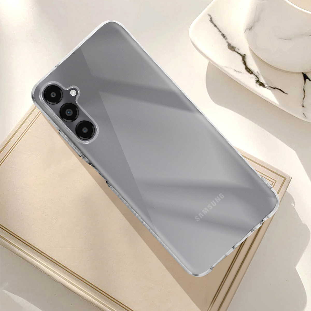 Custodia trasparente per telefono con tre fotocamere su sfondo grigio.