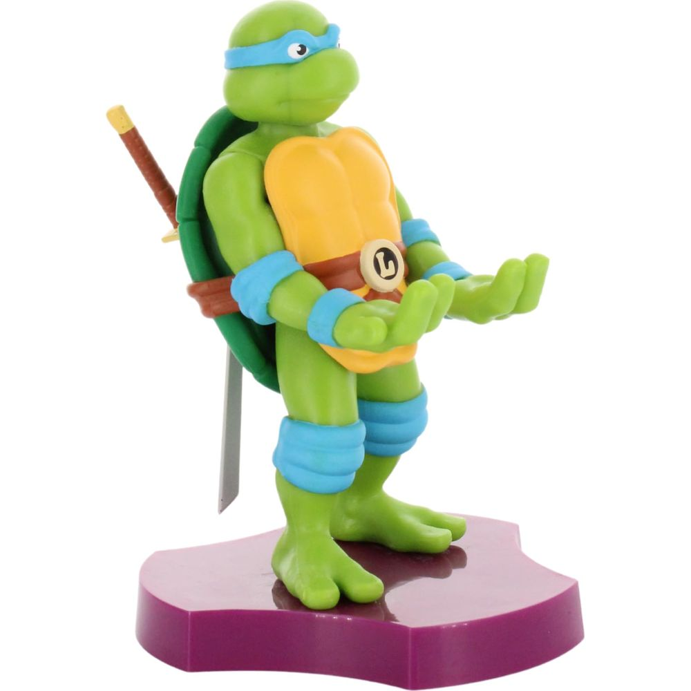 Leonardo z TMNT stoi na fioletowej podstawie z mieczem i otwartymi dłońmi.