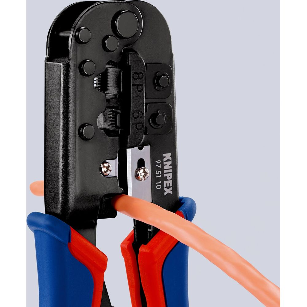 Una herramienta de engarzado KNIPEX negra con mangos naranja y azul sujeta un cable naranja.