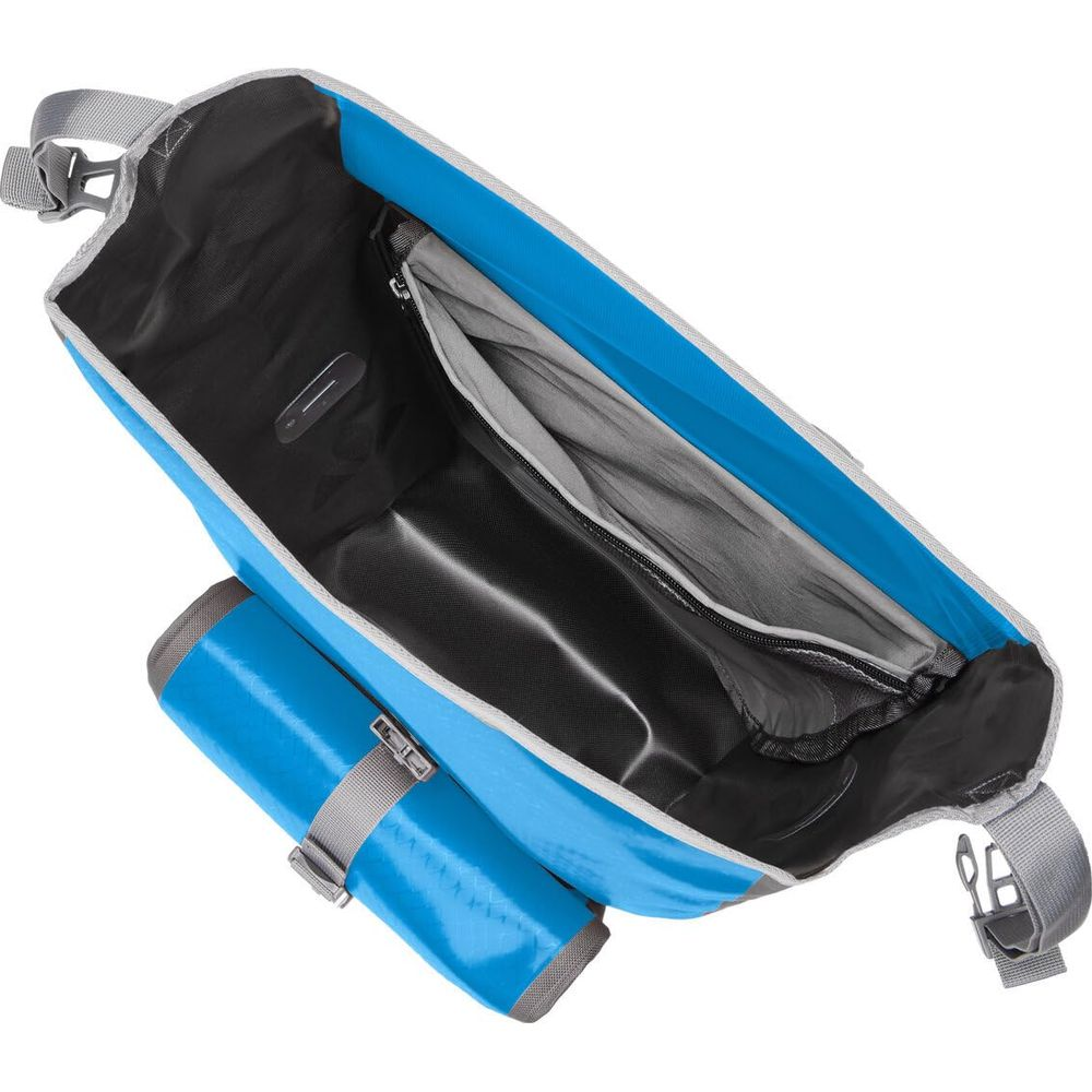 Otwarta niebieska torba z szarym paskiem, wewnętrzną kieszenią na zamek.