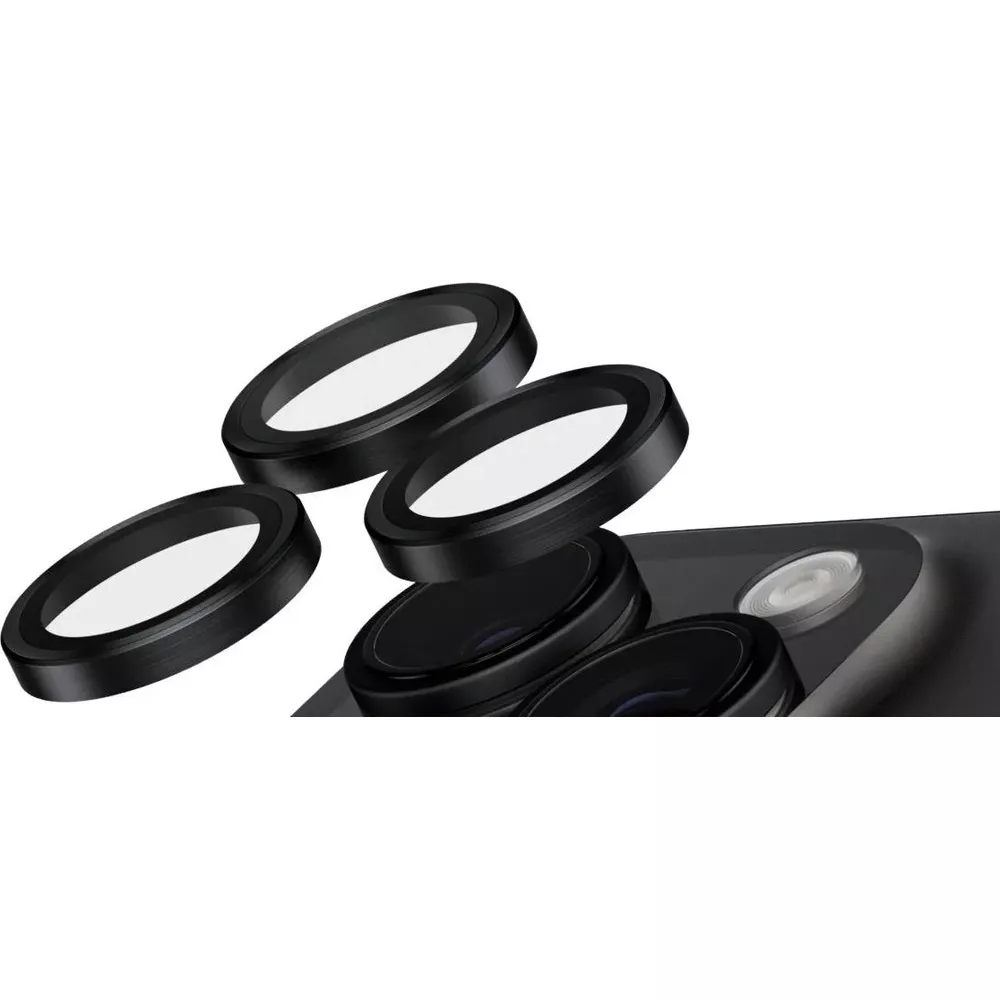 Quatre filtres d'objectif noirs reposent sur une surface sombre à côté d'un objectif de caméra.