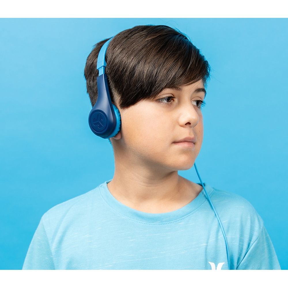Chłopiec w niebieskich słuchawkach i jasnoniebieskiej koszulce na niebieskim tle.