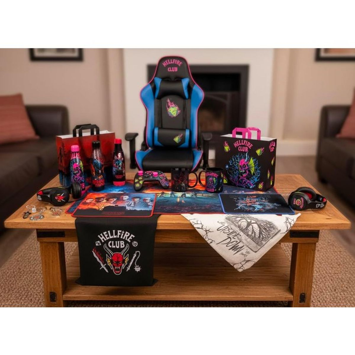 Krzesło gamingowe Hellfire Club, kontrolery, kubki i inne na drewnianym stole.