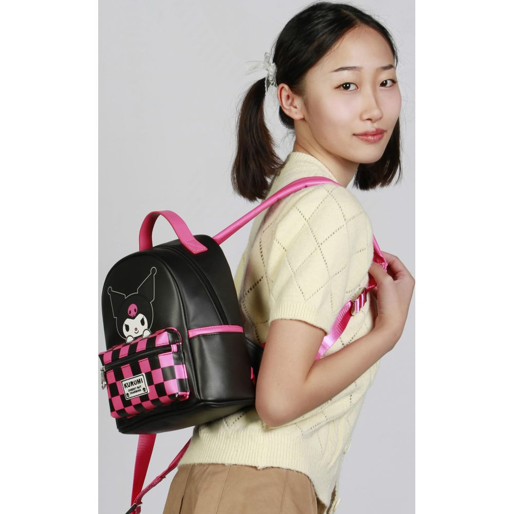 Eine junge Frau trägt einen schwarzen Rucksack mit rosa Trägern und einem Karomuster.