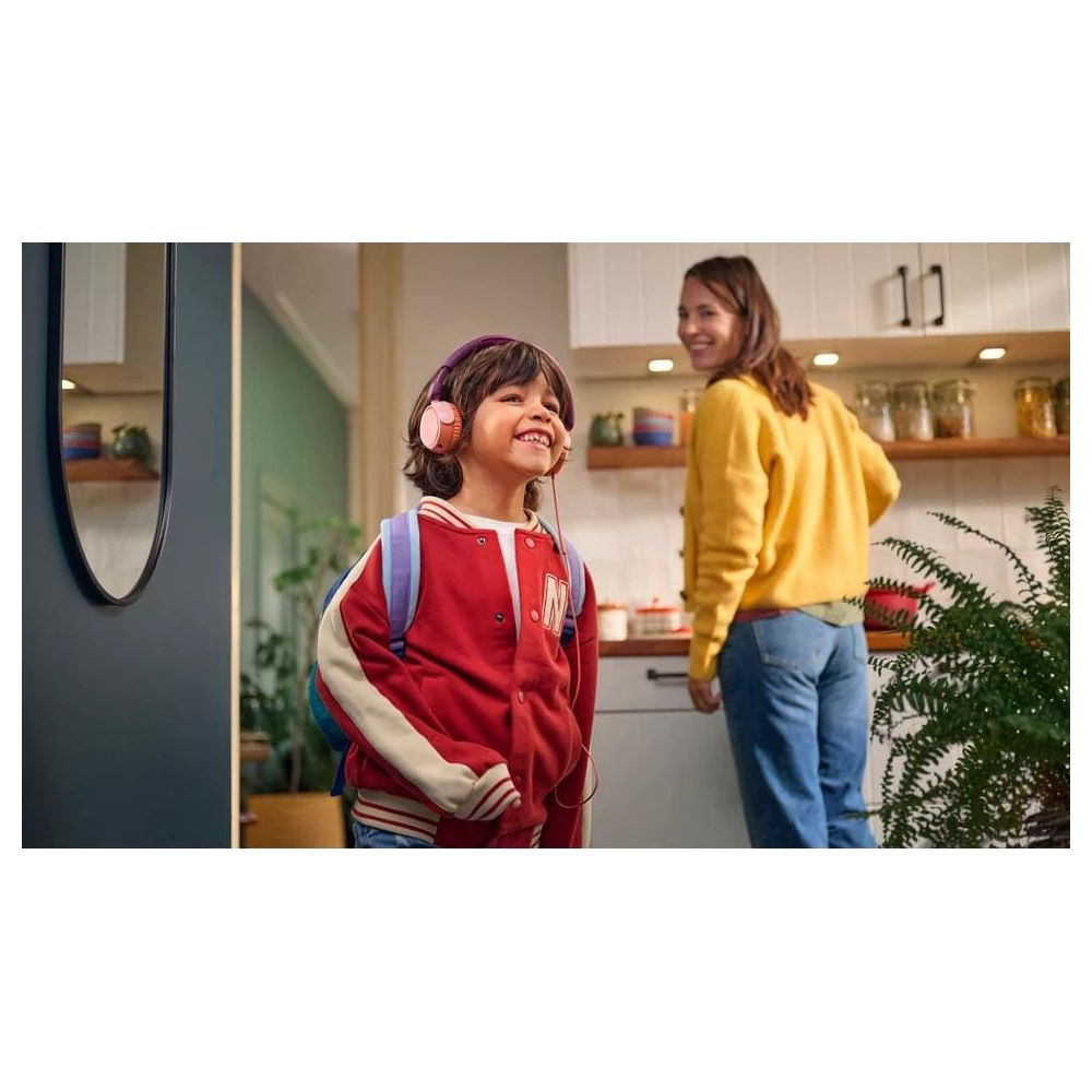 Chłopiec w słuchawkach i z plecakiem stoi przed kobietą w kuchni.