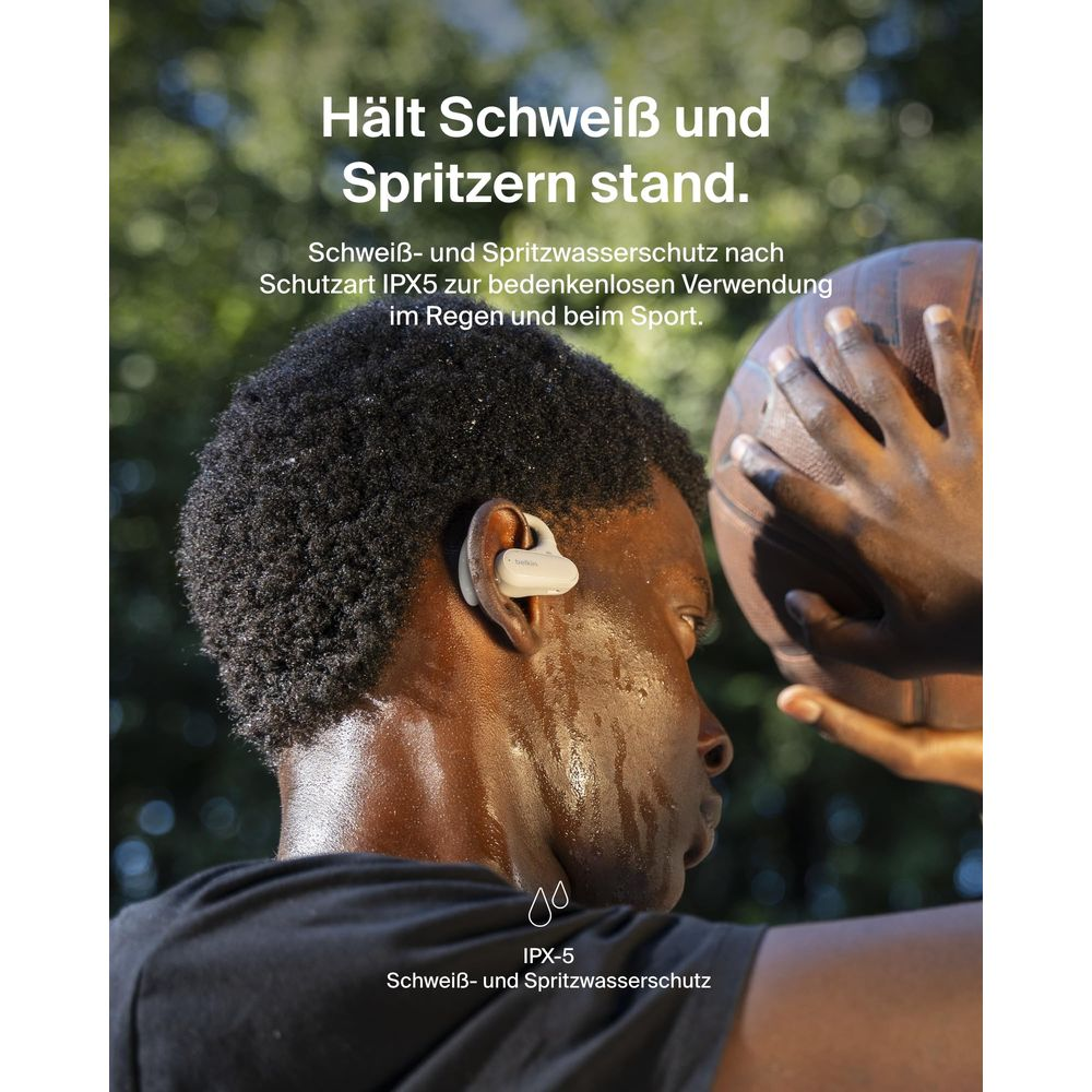 Mężczyzna z potem i piłką do koszykówki, nosi słuchawki.