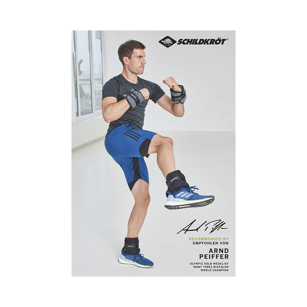 Mann mit Gewichten an Handgelenken und Knöcheln in blauer Hose und grauem Shirt.
