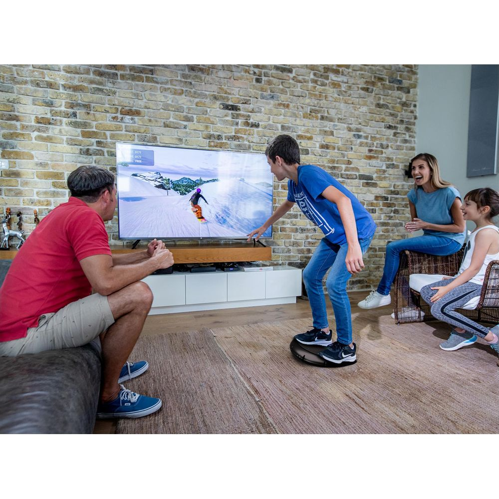 Familie spielt Videospiel auf einem Snowboard-Simulator vor dem Fernseher.