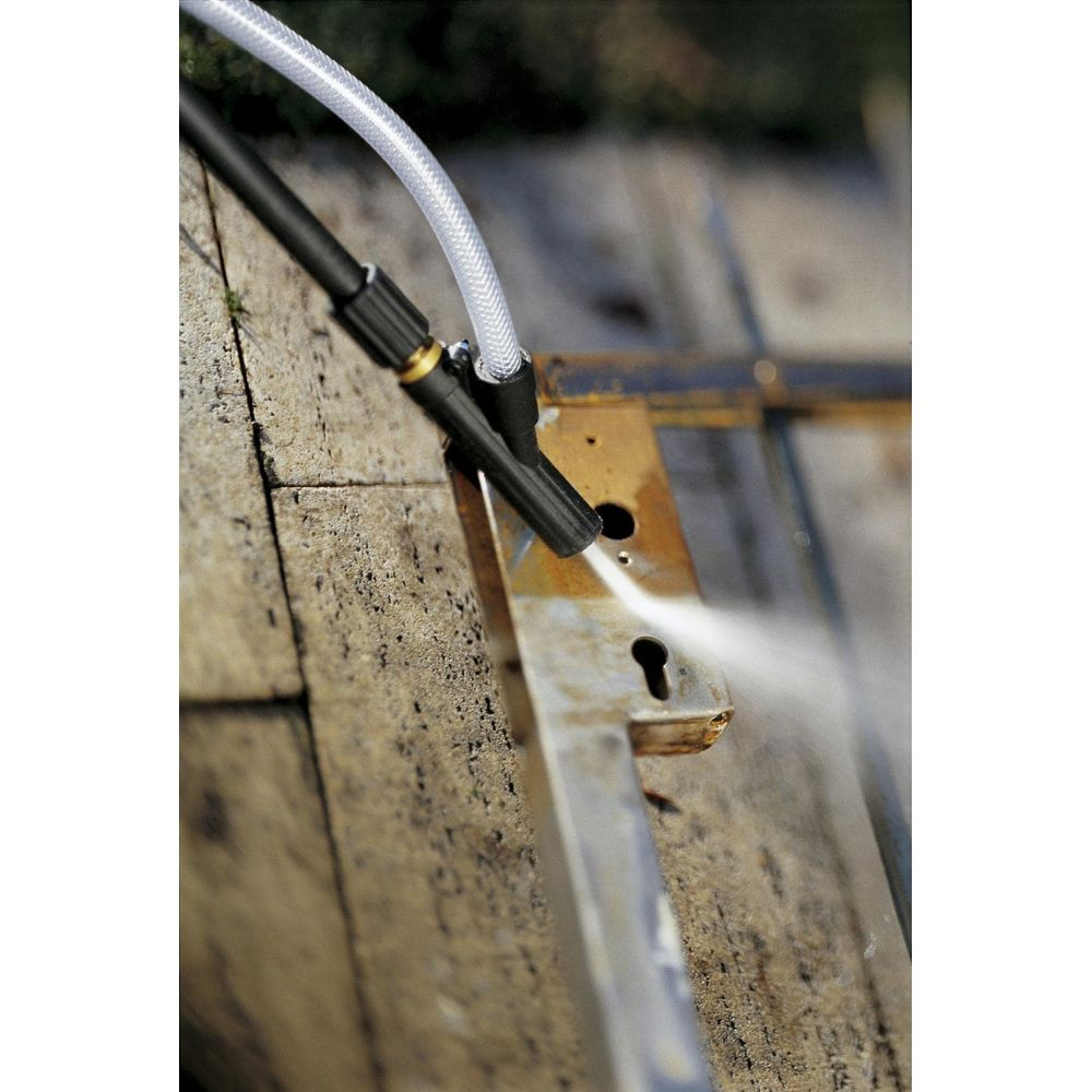 Una hidrolimpiadora rocía agua sobre una superficie metálica oxidada.