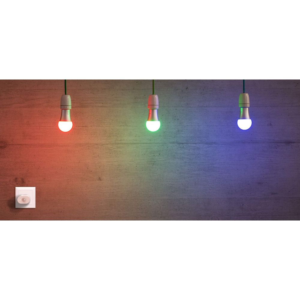 Trois ampoules suspendues s'allument en rouge, vert et bleu sur un mur en bois.