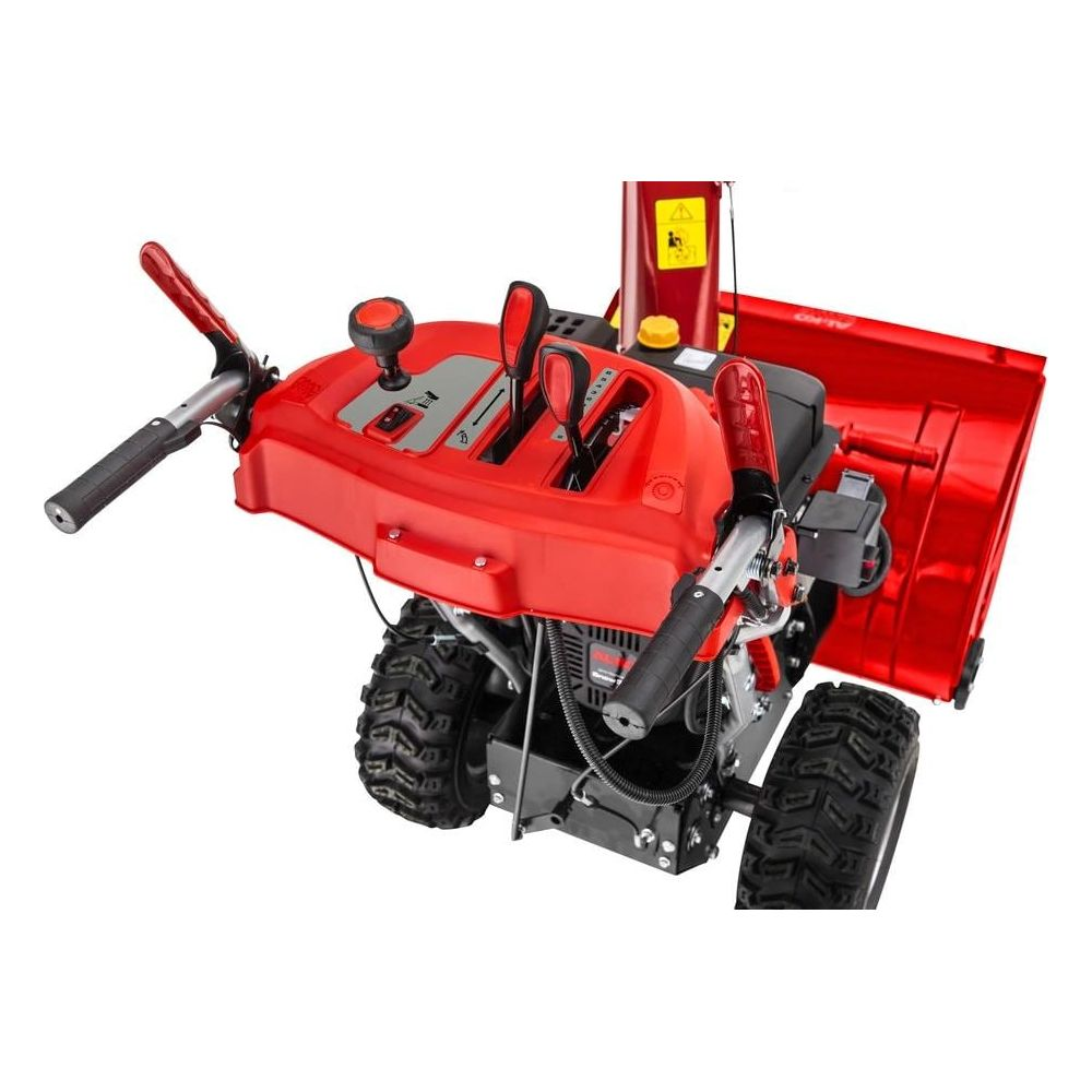 Ein roter Schneefräse mit schwarzen Rädern und Bedienelementen.