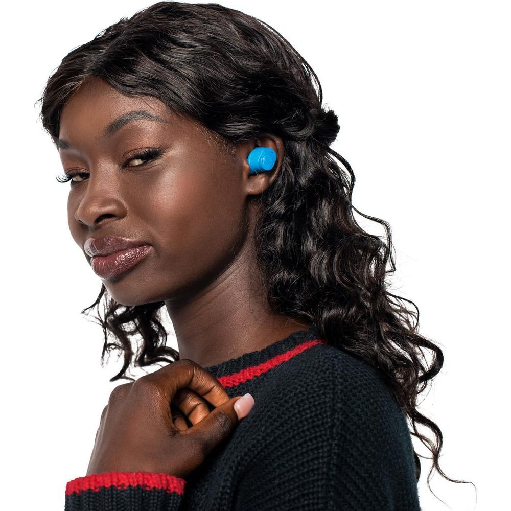 Kobieta o ciemnej skórze nosi niebieski słuchawkę i czarny sweter. Białe tło.