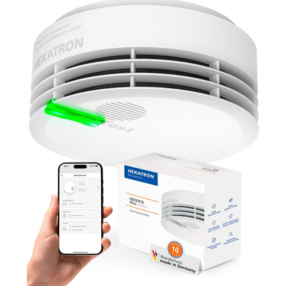 Ein weißer HEKATRON Rauchwarnmelder mit grüner LED, daneben die Verpackung und ein Smartphone.