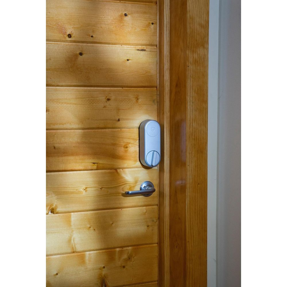 Drewniane drzwi z nowoczesnym srebrnym zamkiem i klamką.