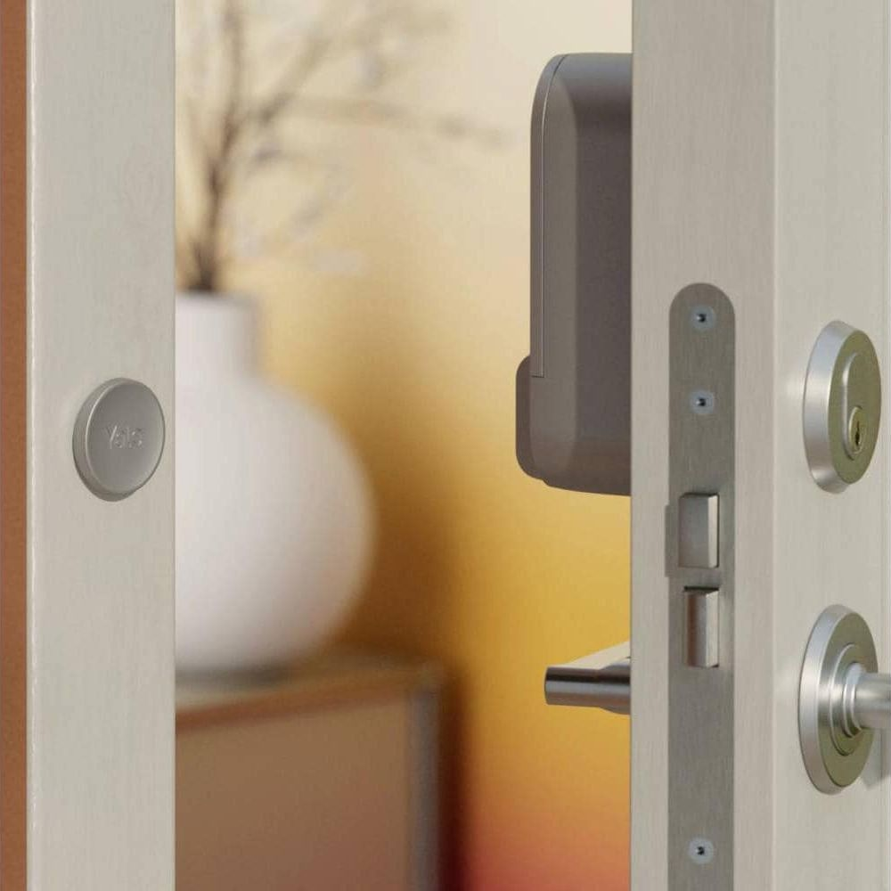 Eine graue Smart-Lock-Einheit ist an einer offenen Holztür montiert.