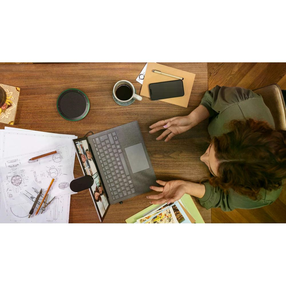 Kobieta przy biurku z laptopem, kawą i dokumentami.