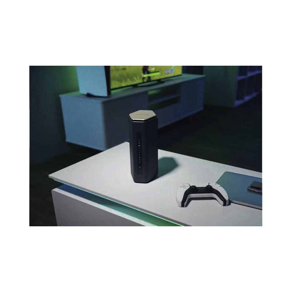 Ein schwarzer Lautsprecher mit goldenem Deckel auf einem Tisch. Daneben ein weißer Controller.