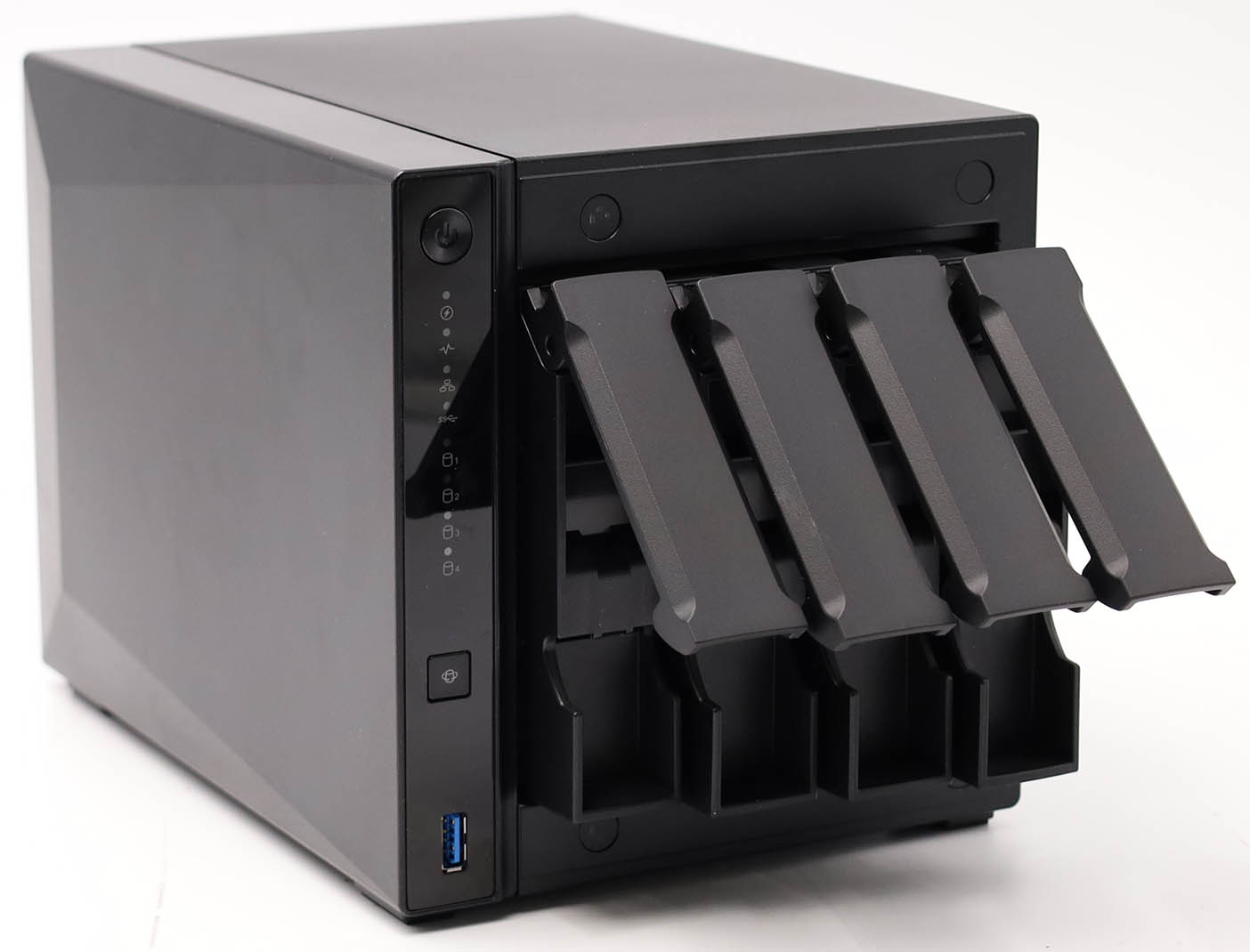 Dispositivo NAS negro con cuatro bahías de disco abiertas y un puerto USB frontal.