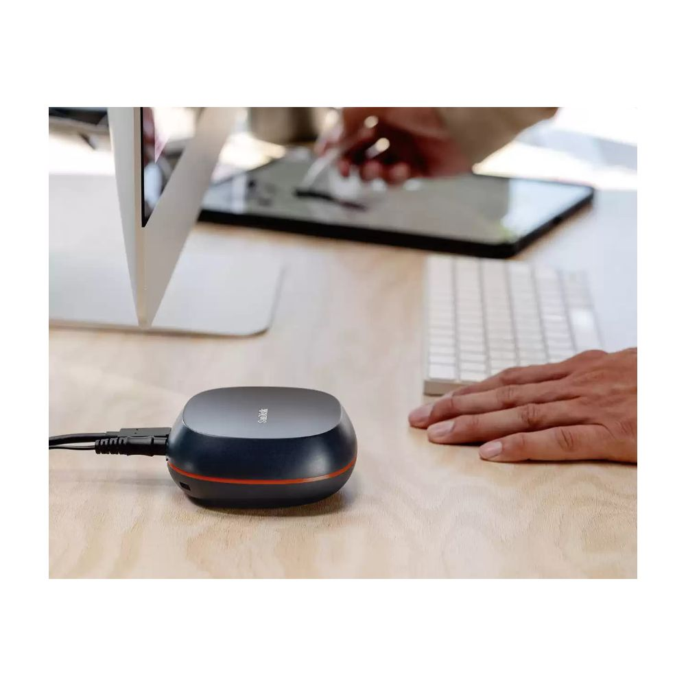 Un appareil SanDisk noir avec une bande rouge, relié par un câble, sur un bureau en bois.