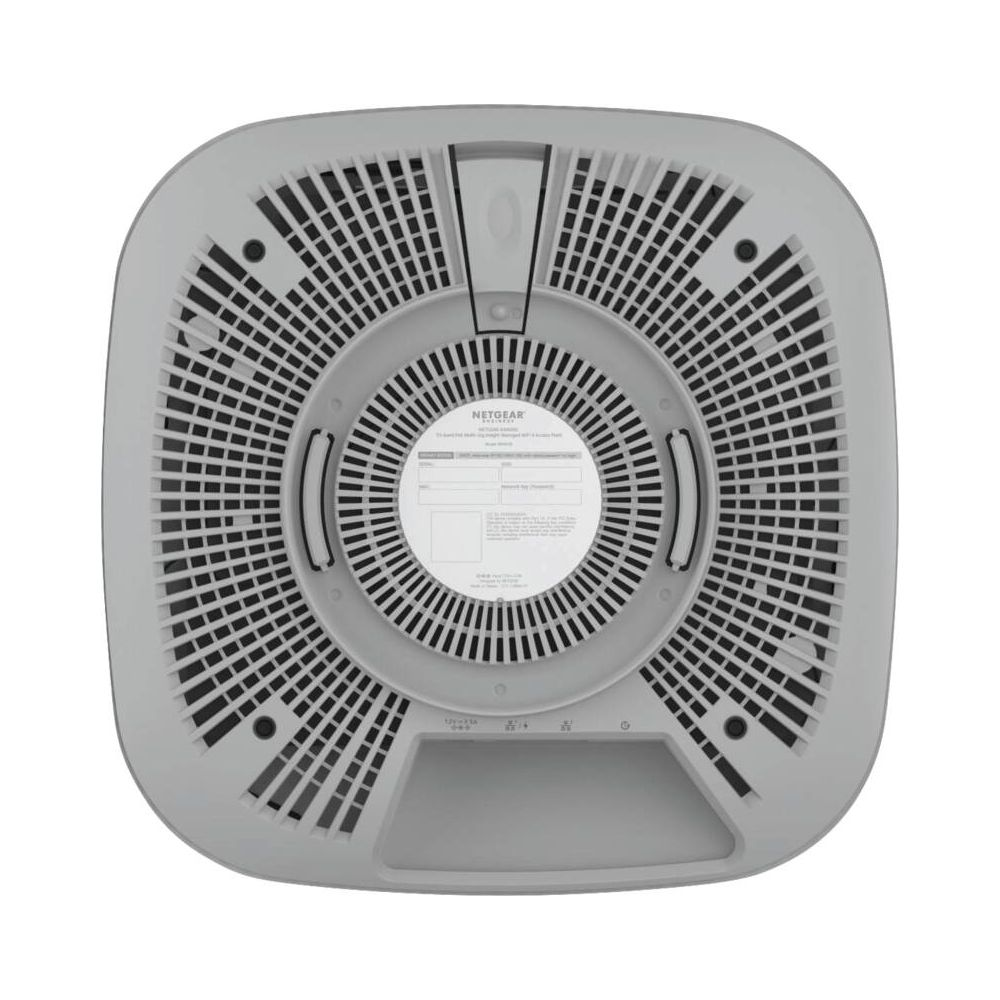 Spód szarego routera Netgear z otworami wentylacyjnymi i portami.