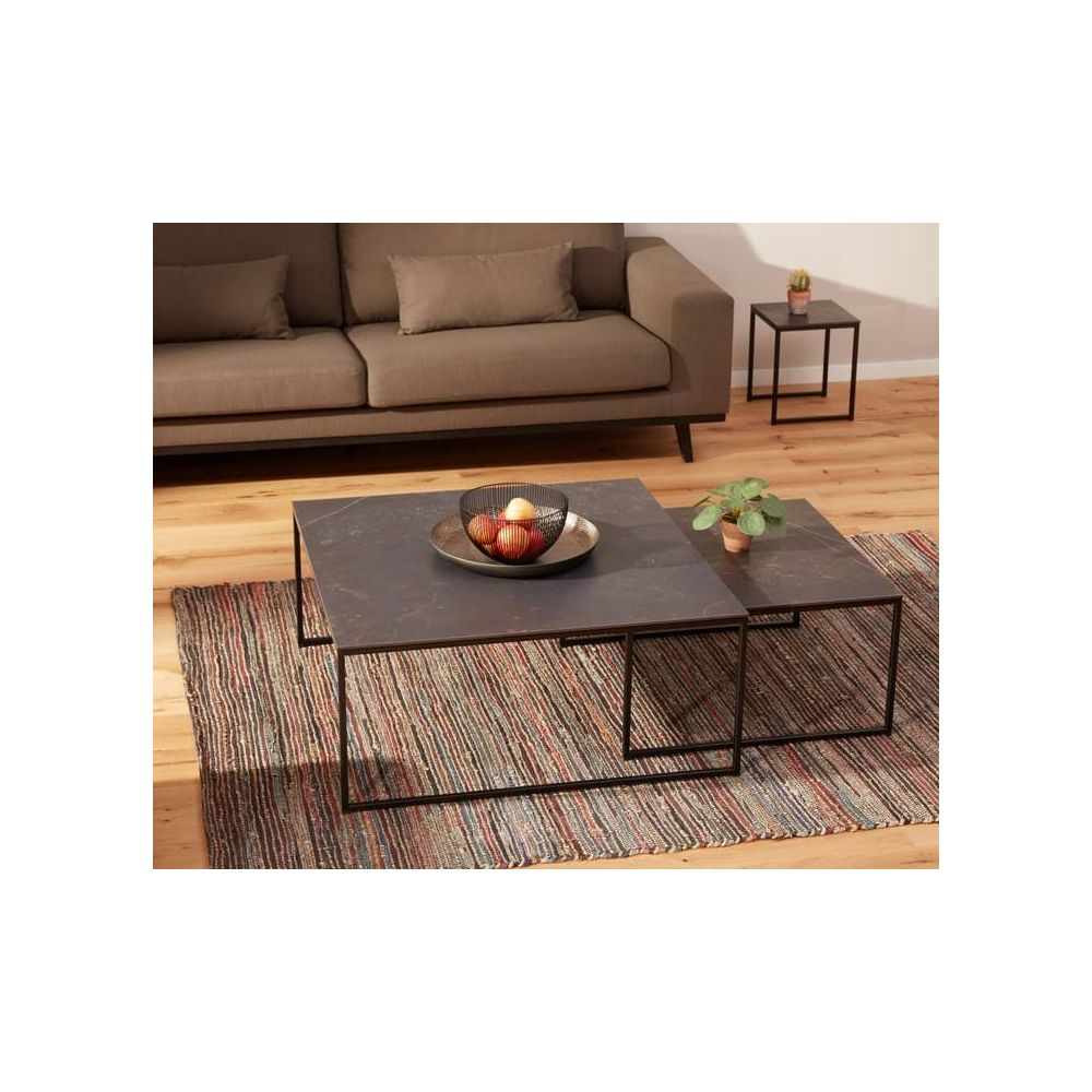 Ein brauner Sofa, zwei Couchtische mit Obst und Pflanze, Teppich, Holzboden.